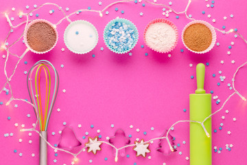 ingredients for baking and kitchen tools with cookie cutter on pink background