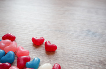 Valentines day card with tiny candy sweet hearts on wooden background. Flat lay, top view, copy space. 