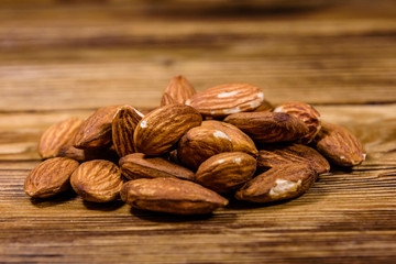 Heap of the peeled almond nuts on wooden table