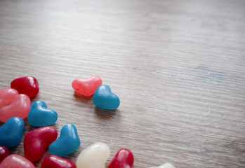 Valentines day card with tiny candy sweet hearts on wooden background. Flat lay, top view, copy space. 