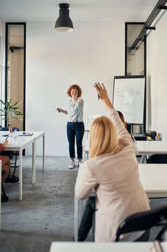 Businesswoman raising her hand during a workshop in conference room