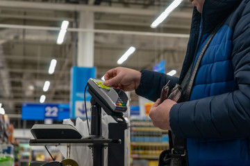 A man pays with a plastic card in a store.