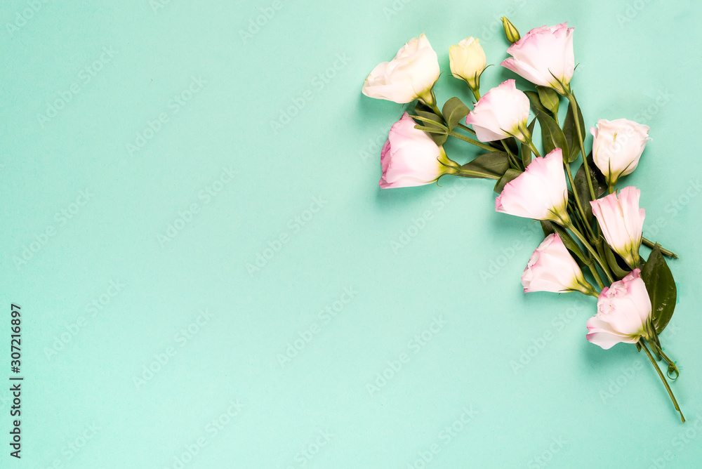 Wall mural Flowers composition. Bouquet of pink flowers eustoma on bleached coral paper background with copy space. Flat lay, copy space