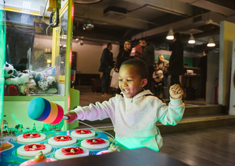 A happy little African boy is having fun in the playroom
