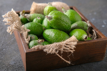 Feijoa fruit in a wooden plate on the table.