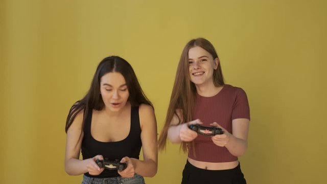 Two girls with excitement are playing a game with controllers