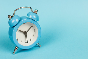 blue alarm clock on a blue background, copy spaсe	