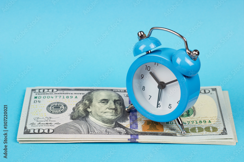 Wall mural money and alarm clock on a blue background, copy spaсe