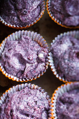 Prepare gluten free blueberries muffin. Raw lilac dough in baking tins