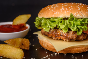Tasty grilled homemade burger with beef, tomato, cheese, cucumber and lettuce