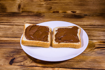 Fototapeta na wymiar Two sandwiches with chocolate spread on a white plate