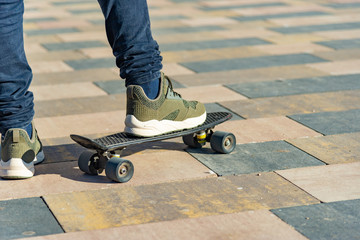 A man stands on one leg on a skateboard preparing for a race.