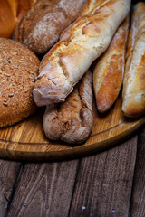 Assortment of baked bread on wooden table background