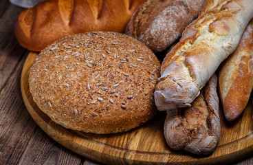 Assortment of baked bread on wooden table background
