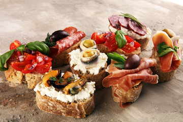 Appetizers table with italian antipasti snacks and wine in glasses. Brushetta or authentic traditional spanish tapas set, cheese variety