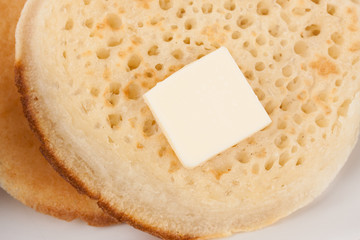 Closeup on fresh British crumpets with piece of butter