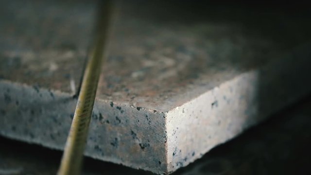 Measuring tape in manufacture of granite slab in production, closeup view.