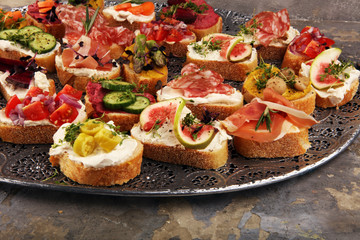 Assorted bruschetta with various toppings. Appetizing bruschetta or brie crostini. Variety of small sandwiches. Mix bruschetta on table