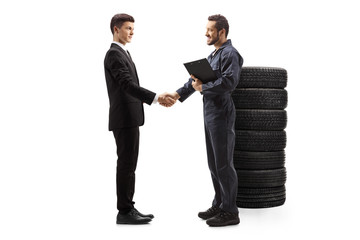 Auto mechanic shaking hand with a young guy in a suit