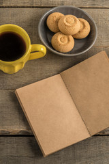blank notebook, coffee and cookies on a wooden table