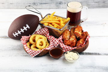 chicken wings, fries and onion rings for football on a table. Great for Bowl Game party
