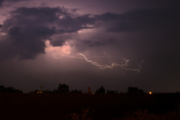 Dramatic nature scene with lightning bolt splitting through the night sky