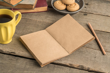 blank notebook, coffee and cookies on a wooden table