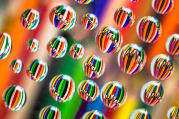 Drawing pencils reflected on waterdrops resting a piece of glass