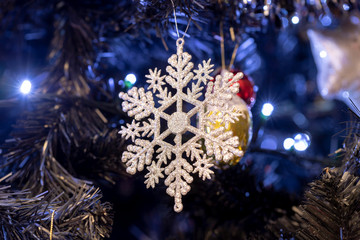 Snowflake Christmas decoration with shiny glare hanged on tree