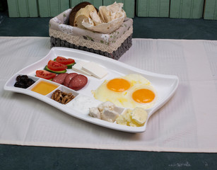 tasty breakfast, honey, egg, sausage, olives, tomato and cucumber on the table