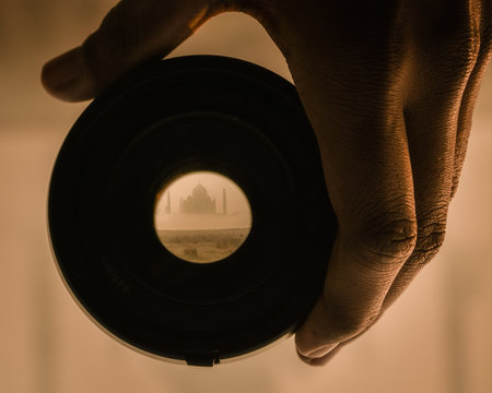 Person holding camera lens