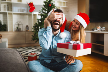 Young love couple exchanging Christmas gifts