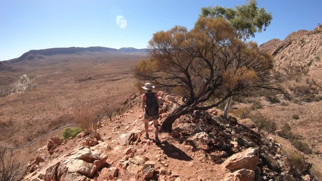 third person view of woman trekking at Ormiston Pound Walk in West MacDonnell Ranges. Mount Sonder lookout, one of highest mountains in Northern Territory, Australia Outback.