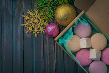 Tasty french macarons and christmas decorations on wooden background