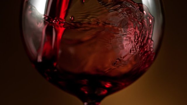 Super Slow Motion Detail Shot of Pouring Red Wine on Luxury Gradient Background at 1000fps.