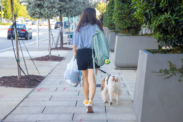 woman walking with her dog in city