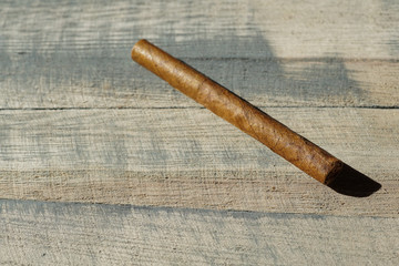 A single cigar on a wooden table