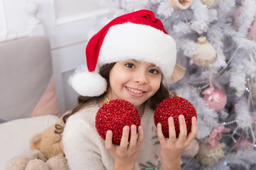 Go for happy vibe with red ball ornaments. Happy child celebrate Christmas and new year. Little santa happy smiling at xmas tree. Mery Christmas. Happy new year
