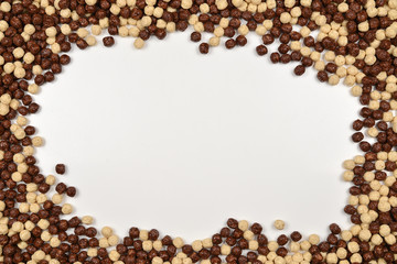 Frame of chocolate corn flakes  isolated on white background.