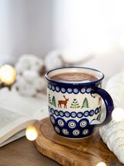 Beautiful mug with a hot drink (Polish Pottery mug) with bokeh lights in the background