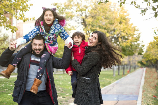 Autumn image of happy four members family in public park