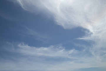 Pale blue sky with swirling clouds on top and bottom