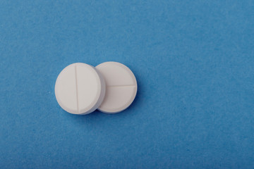 Two pills on a blue background, medicine,