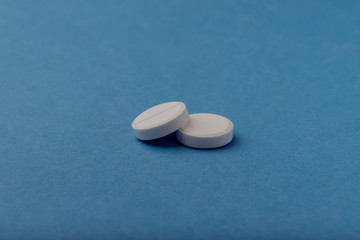 Two pills on a blue background, medicine,