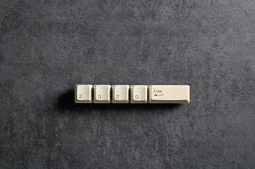 Computer keyboard keys with 2020 enter written using the white buttons on a dark background....