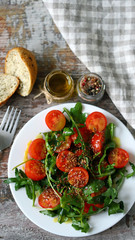 Healthy salad with arugula and cherry tomatoes with mustard sauce. Vegan food.