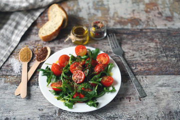 Healthy salad with arugula and cherry tomatoes with mustard sauce. Vegan food.
