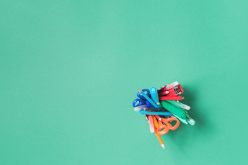 Assorted office and school stationery in a glass flat lay on green