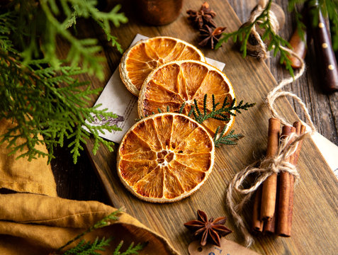 dried orange slices on wooden board with anise stars, cinnamon sticks