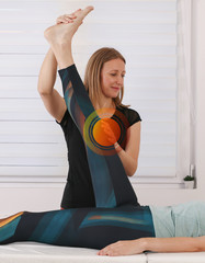 Therapist treating injured knee of athlete female patient . Sport physical therapy , Osteopathy